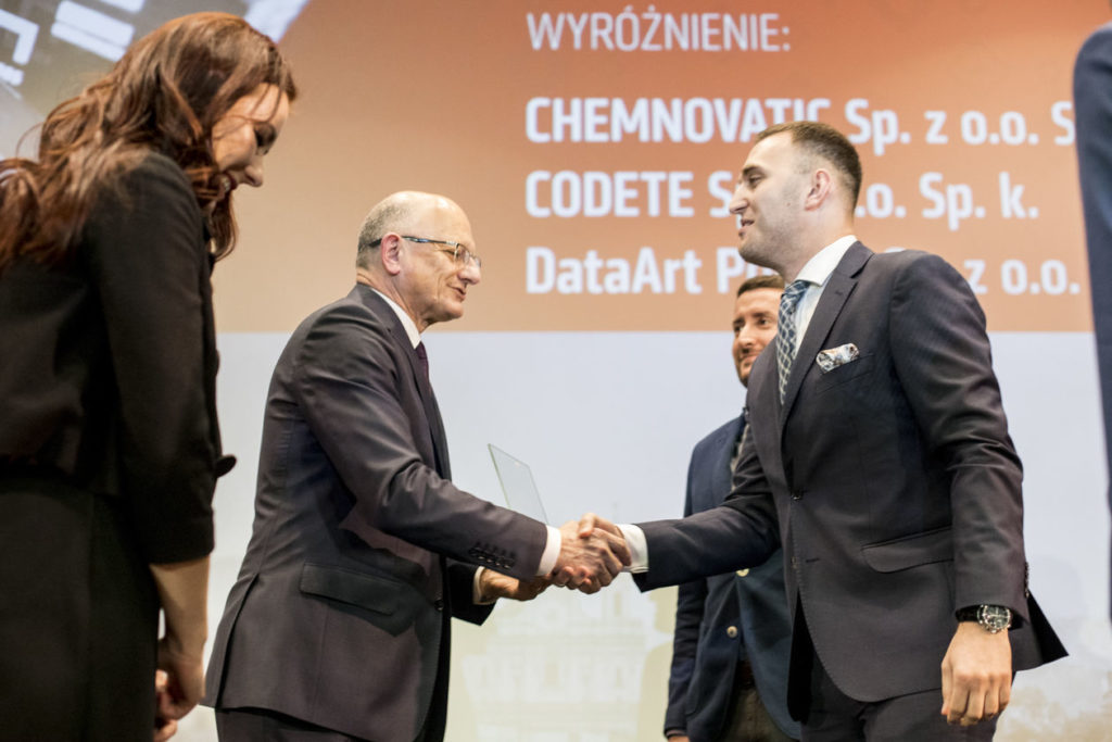 a woman on the left, and 2 men shaking hands - Mayor of Lublin, Mr. Krzysztof Żuk and Chemnovatic CEO Marcin Ławecki