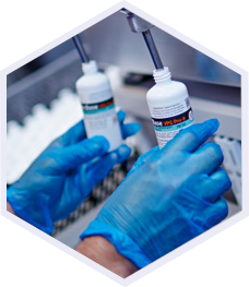 hands in gloves holding 2 different nicbase bottles in a lab environemnt